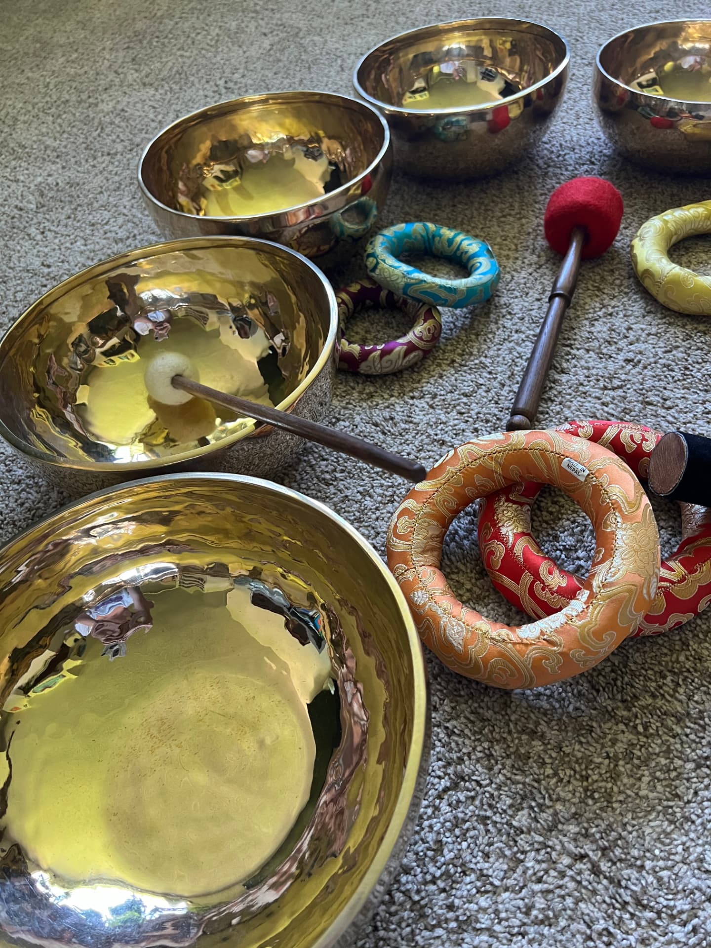 Handmade Tibetan sound bowls with decorated cushion rings and mallets