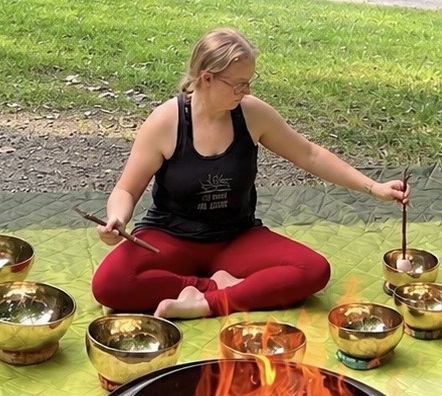 Emily Curry playing Tibetan sound bowls outdoors